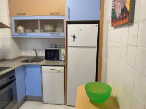 格罗韦SAN VICENTE DO MAR (URBANIZACIÓN PEDRAS NEGRAS) O GROVE- SANXENXO的小厨房配有冰箱和微波炉。
