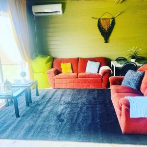 科克尼斯Kempings Kalnavoti的客厅设有两张红色的沙发和一个黄色的墙壁
