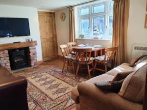 绍斯波特The Coach House Holiday Cottage, Southport的客厅配有桌子和壁炉