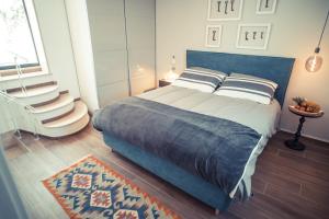 奥斯图尼800s Home Luxury Rooms的一间卧室配有带枕头和地毯的床