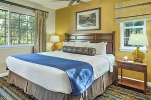 派托普湖畔派恩托普公寓式酒店的一间卧室设有一张大床和两个窗户。