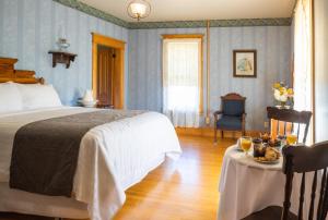 BertrandHôtel Château Albert的一间卧室配有一张床和一张桌子,上面有食物