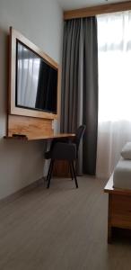 梅青根HB 32 Metzingen的客房设有书桌、电视和椅子