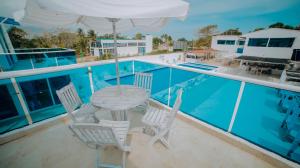 科韦尼亚斯Hotel Palma Linda的游泳池旁带桌椅的天井