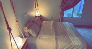 达曼شاليهات 4U vip的一间卧室设有秋千床和窗户。