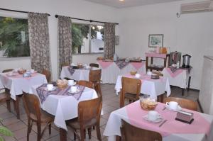 阿蒂加斯HOTEL DEL NORTE的用餐室配有桌椅和白色的桌布