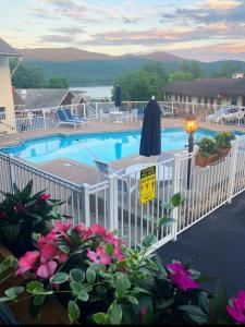 乔治湖Nordick's Inn的一座带白色围栏和粉红色鲜花的游泳池