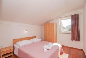 耶泽拉Apartmani Horvat的一间卧室配有一张床,上面有两条毛巾