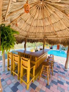 奥拉涅斯塔德La Felicidad Aruba的草伞下的一张木桌和椅子