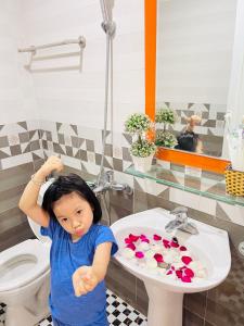 吉婆岛谭春酒店的站在浴室水槽前的小女孩