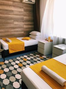 伊热夫斯克以塔马斯酒店的一间设有两张黄色和白色床铺的客房