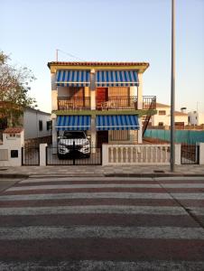 贝利雷瓜尔德Apartamentos playa de bellreguard,gandia,oliva,denia,benidorm的街道上带有蓝色和白色条纹的建筑