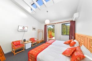 卢拉Sinofield Edu-Retreat的一间卧室配有红色枕头的床
