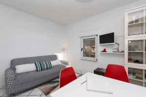 托尔博莱Torbole Holiday House Appartamento con giardino的客厅配有沙发和2把红色椅子