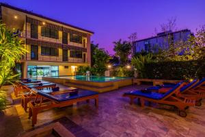 清迈萨库查广场酒店的一个带躺椅的庭院和一个游泳池