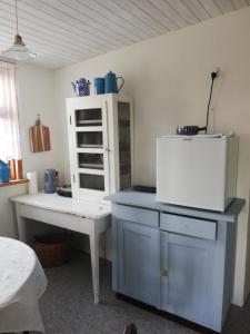 斯文堡Tankefuld Living's Horsefarm的客房设有带桌子和冰箱的厨房。