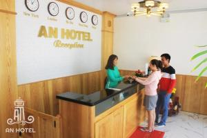 潘切An Hotel Phan Thiết的一群人站在酒店柜台上