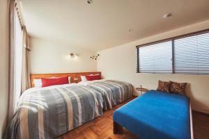 镰仓市THE FLOW KAMAKURA的一间卧室配有一张床和一个蓝色长椅