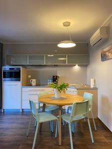 斯蒂格纳Apartament BalticPark Stegna的带木桌和椅子的厨房以及带白色家电的厨房。