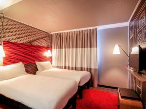 卡奥尔ibis Cahors的酒店客房设有两张床和电视。