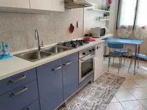 帕代诺杜尼亚诺Appartamento “Liberty”的厨房配有水槽和炉灶