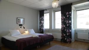 哥德堡太乐床和早餐哥德堡城大酒店的一间卧室设有一张床和两个窗户。