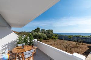VromonérionRizes Seaside Homes的阳台配有桌子,享有海景。