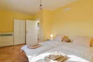 亚伊萨Casa Uva的黄色墙壁客房的两张床