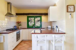 亚伊萨Casa Uva的厨房配有白色橱柜和绿色窗户。