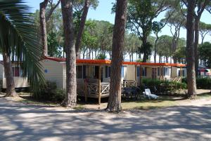 CalmasinoCasa Mobile - Cisano San Vito ****的一座带门廊和一群树木的房子