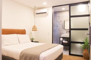麦德林574 Hotel的一间卧室设有一张床和一间浴室。