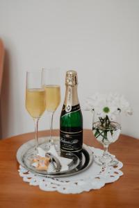 赫任斯科Hotel U Lípy的一瓶香槟和一张桌子上的两杯酒