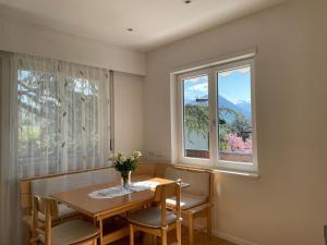 梅拉诺Naif-Home的一间带桌子和2个窗户的用餐室