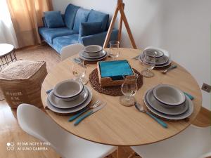 马尔皮卡Malpica Nordic Home的一张木桌,上面放有盘子和酒杯