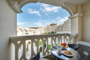 瓦尔纳Summertime in Varna South Bay Beach Residence的阳台配有带食品的桌子,享有建筑的景致。