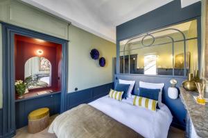 雷恩LE CELESTINE - Centre Historique -的一间卧室拥有蓝色的墙壁,配有一张带枕头的床。