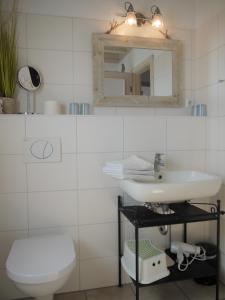 希尔克道夫Ferienhaus Oceanview的白色的浴室设有水槽和镜子