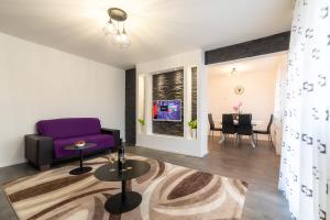斯诺基Apartman MELANI的客厅配有紫色沙发和桌子