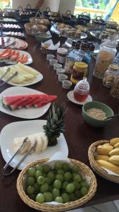 乌巴图巴Pousada Vista Dell Mar的餐桌,盘子上放着食物,水果和蔬菜