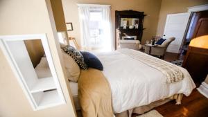 亨廷顿Chessie Room的卧室配有白色的床和镜子