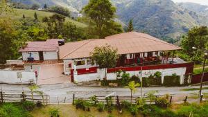 马尼萨莱斯Eco Lodge La Juanita的山上有红色屋顶的房子
