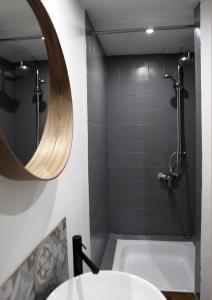 杜柏La ruelle的浴室配有盥洗盆、镜子和浴缸