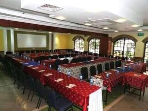 内罗毕Upper Hill Guest House Nairobi的一个带红色桌椅的大型宴会厅