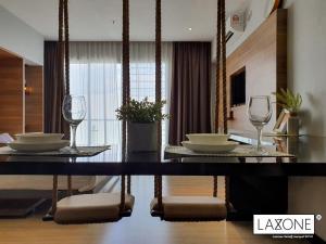 哥打京那巴鲁Aeropod Sovo Studio - Laxzone Suite的一间用餐室,配有两杯玻璃和桌子