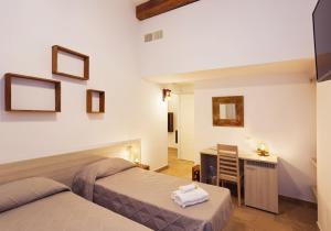 文蒂米利亚Casa Porta Marina的酒店客房配有两张床、一张书桌和一张书桌。