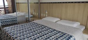 皮帕Pipas Ocean Prime Vista Mar的一间卧室配有两张床和镜子