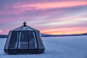 耶利瓦勒Laponia Sky Hut的冰冻湖上的玻璃冰屋,日落