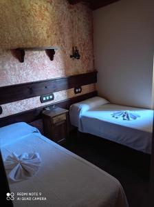 PradoCasa rural "Matela"的酒店客房,配有两张带白色床单的床