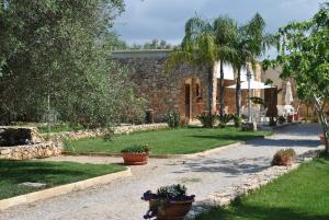 切萨雷奥港博尔戈康索尔住宿加早餐旅馆的石头房子,花园内种有盆栽植物