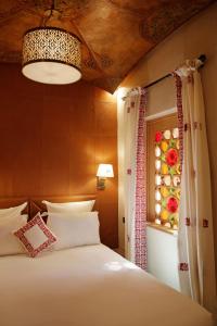 马拉喀什Elegancia Riad Boutique & SPA的一间卧室设有一张大床和一个窗户。